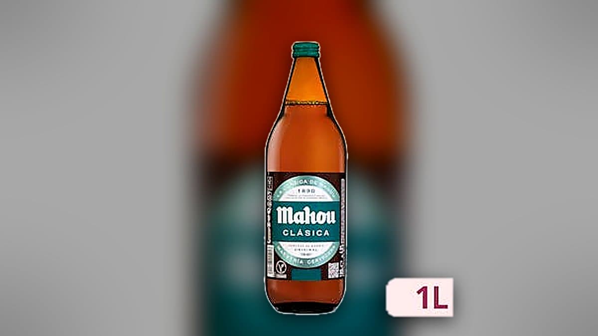 Botella de cerveza Mahou de un litro fría con condensación, luz de atardecer cálida, fondo desenfocado.