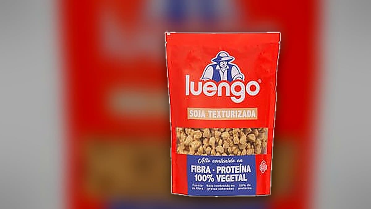 Tazón con soja texturizada Luengo junto a plato de boloñesa casera, paquete de producto de fondo con iluminación cálida
