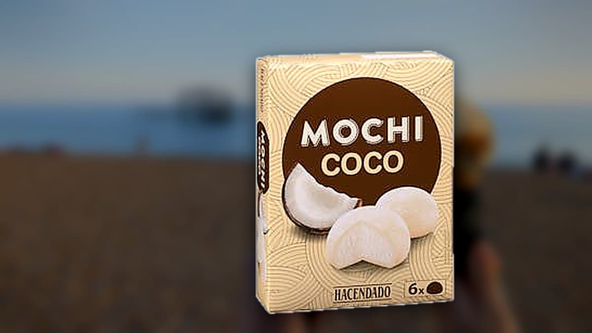 Bolas de helado mochi de coco con condensación en plato frío, caja de Hacendado al fondo, iluminación azul de congelador contrastando con tonos cálidos de verano