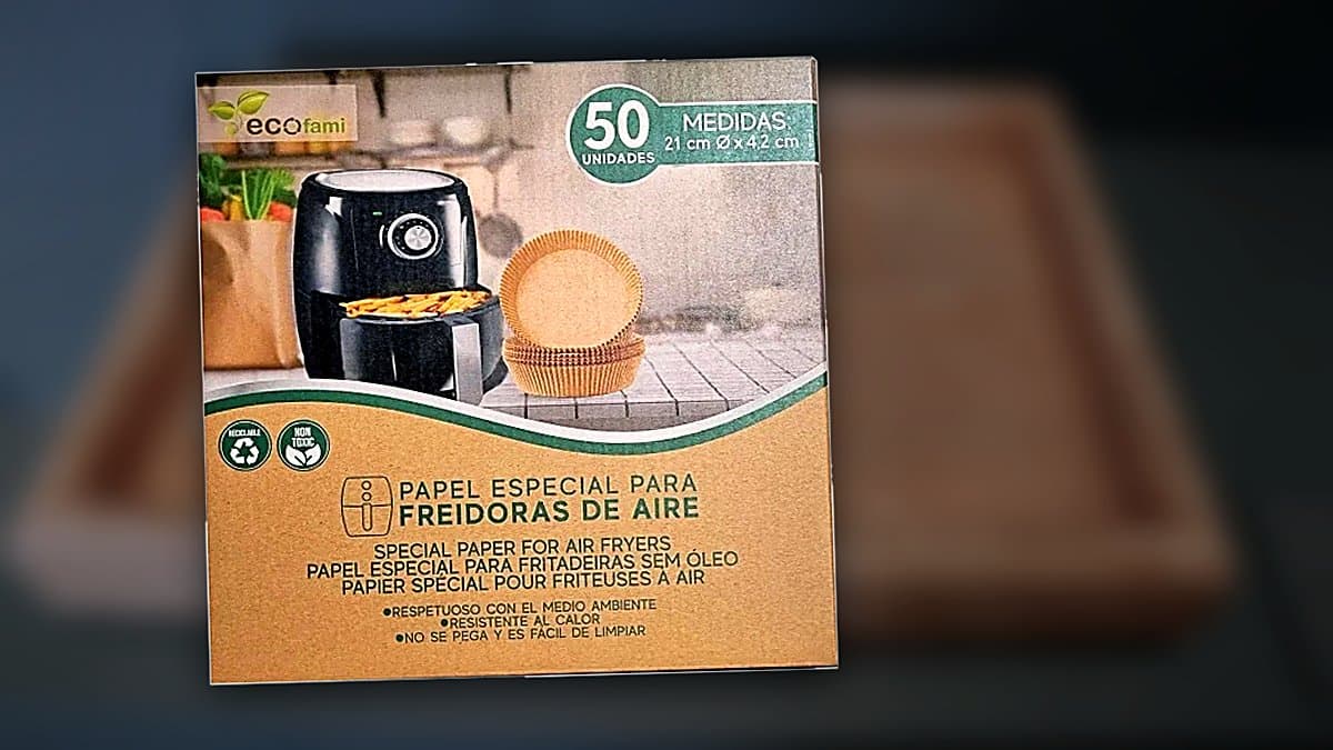 Papel molde desechable para freidora de aire junto a cesta de freidora en cocina moderna