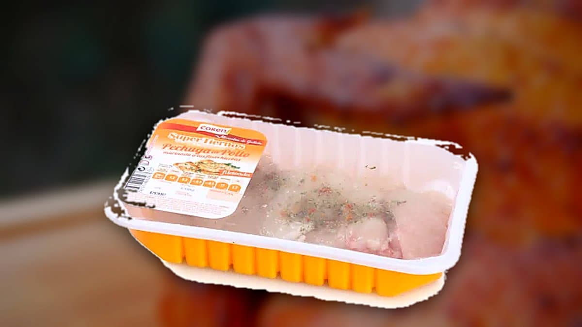 Pechuga de pollo fileteada marinada a las finas hierbas en bandeja de Carrefour sobre mostrador de carne fresca.