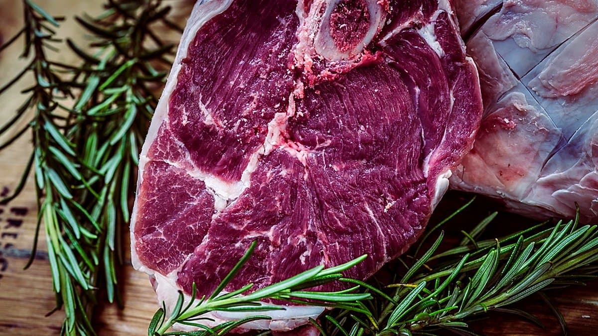 Mostrador frigorífico de carnes frescas en supermercado con bandejas de ternera, pollo y cerdo bajo iluminación LED de display