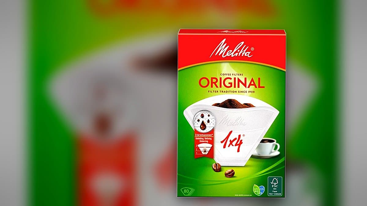 Filtros de papel Melitta en abanico junto a cafetera de goteo clásica en encimera de cocina, luz matinal cálida, vapor de taza fresca