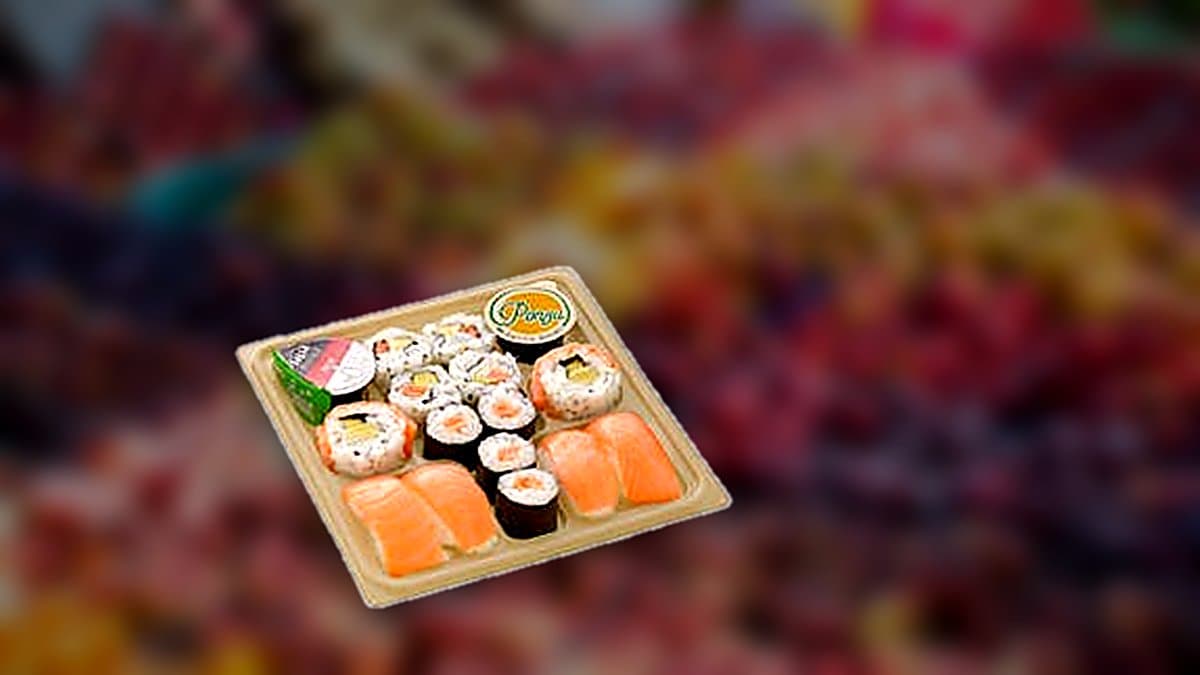 Bandeja de sushi Bento con uramakis, makis, nigiris y futomakis sobre mesa de verano con palillos y salsas.
