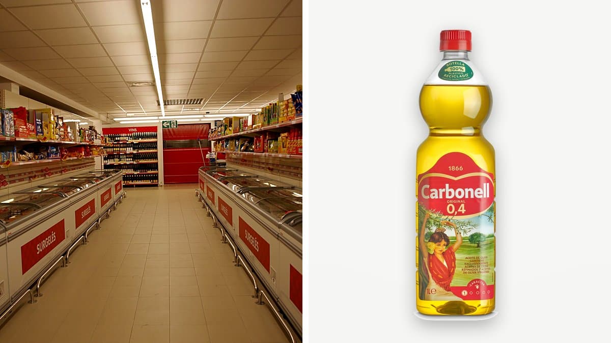 Botella de un litro de aceite de oliva suave Carbonell en la estantería de un supermercado, con la etiqueta de precio en primer plano, mano de cliente alcanzando la botella, reflejo dorado a través del cristal.