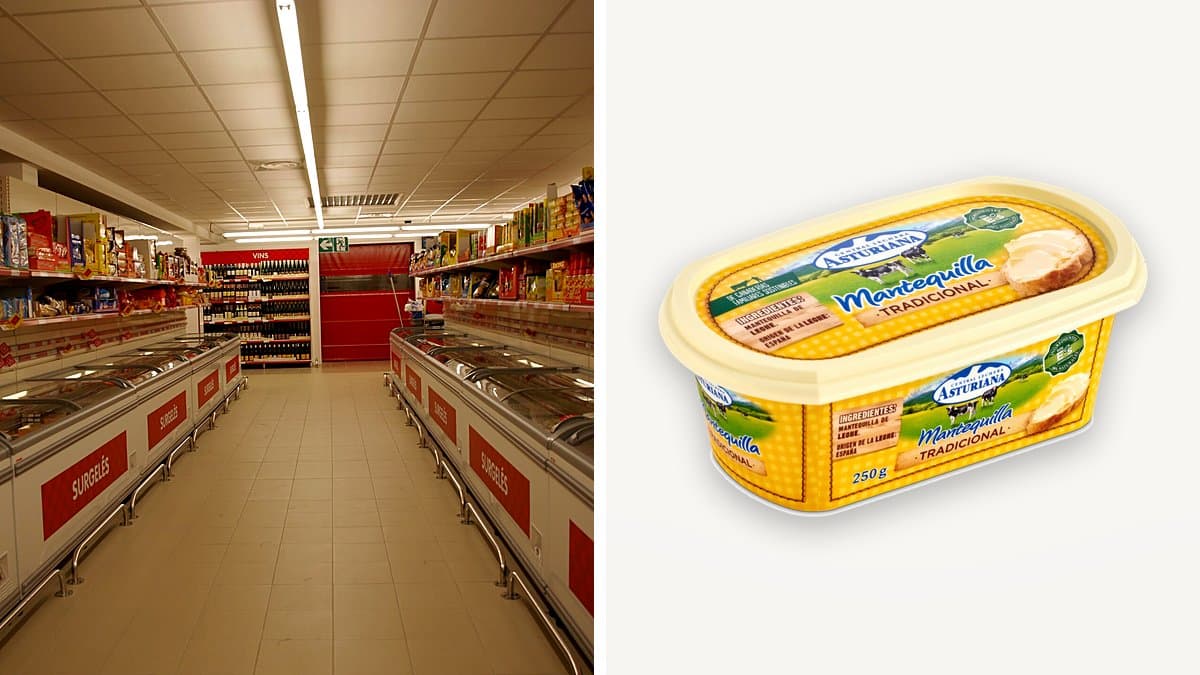 Bloque de mantequilla Asturiana de 250 gramos en su envase en una sección de lácteos refrigerada, condensación en el envoltorio, una rebanada de pan tostado con mantequilla a un lado, iluminación cinematográfica fría