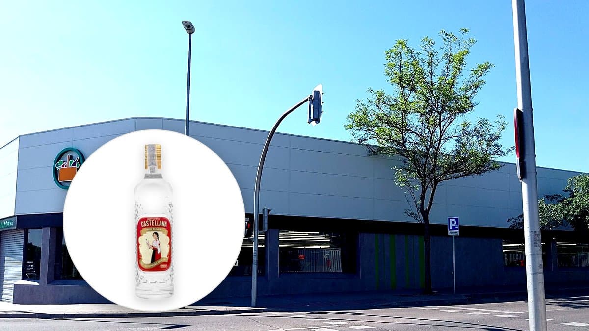 Botella de licor de anís dulce La Castellana junto a una copa vertida sobre una barra de mármol, con luz de tarde.