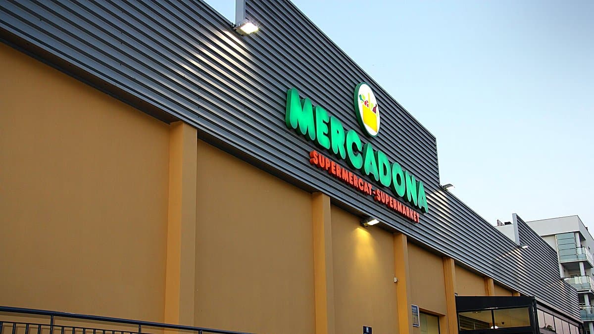 Pasillo de supermercado con estanterías de aceite y huevos, comprador en movimiento desenfocado, iluminación cálida editorial