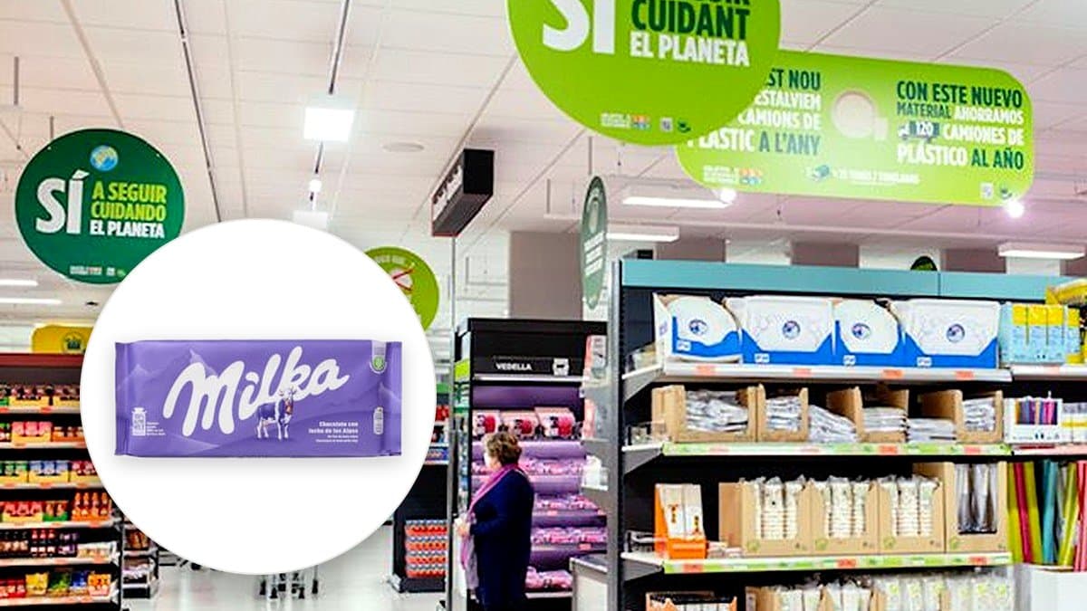 Tableta de chocolate con leche Milka abierta sobre mesa de madera con luz cálida natural