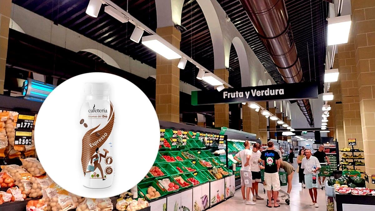 Mostrador de cafetería dentro de supermercado Mercadona con máquina de café recién molido, cliente bebiendo, luz cinérica, sin logos intrusivos