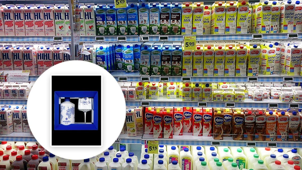 Folleto de supermercado abierto en una mesa de cocina junto a una lista de compra y una taza de café, luz natural de la mañana