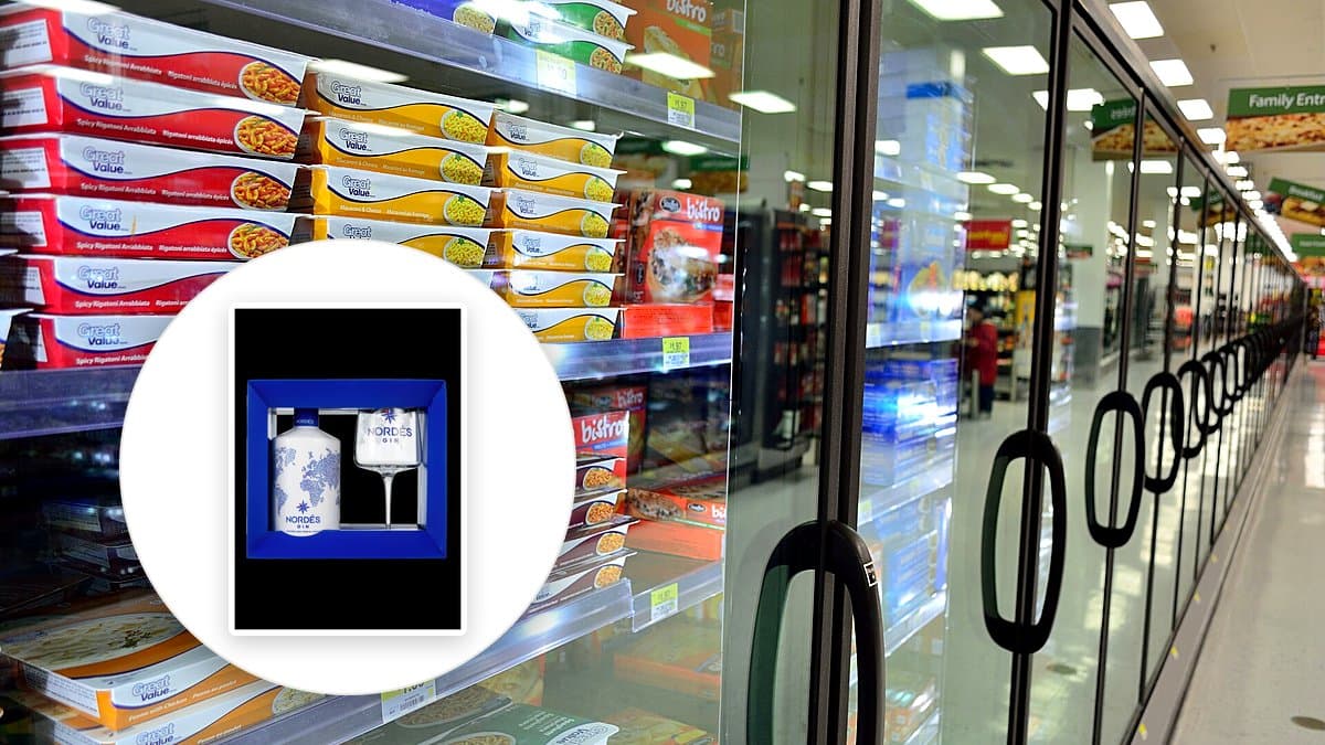 Manos sosteniendo un folleto de ofertas de supermercado abierto frente a estantes con productos, iluminación natural de tienda, fotografía editorial