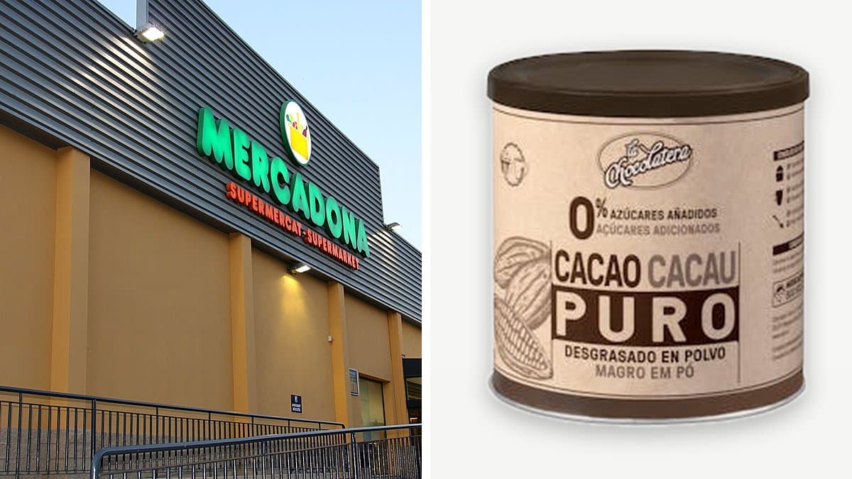 Bote abierto de cacao puro La Chocolatera sobre mármol con cucharada y vaso de leche tibia al fondo, luz matinal lateral