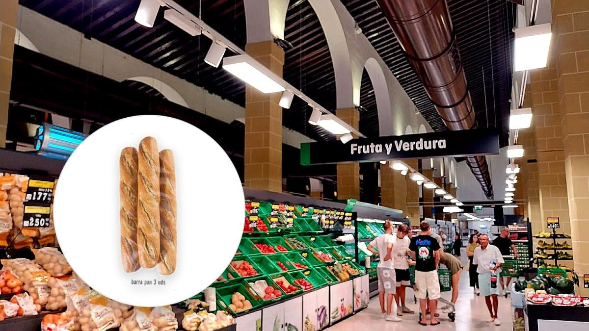 Tres barras de pan fresco en bolsa de papel sobre tabla de madera con crumbs dispersos