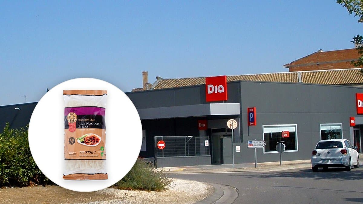 Paquete de noodles de arroz Tiger Khan en la estantería de Día, detalle de la mano de un comprador leyendo la etiqueta trasera