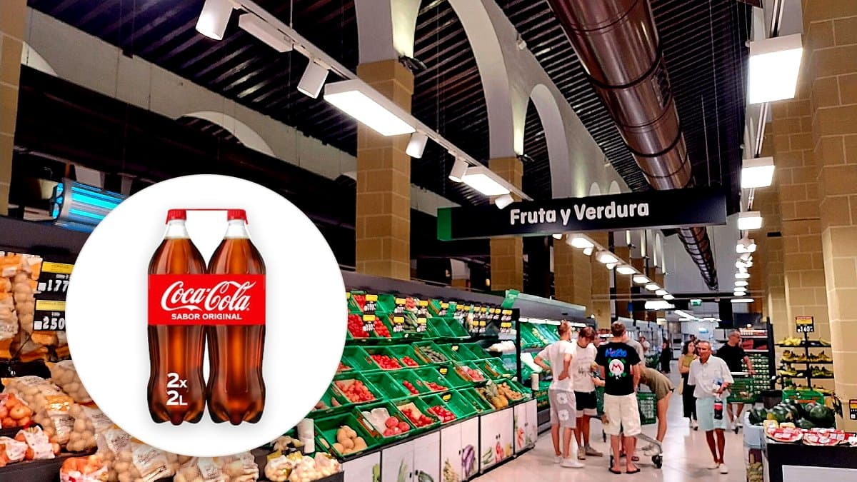 Pack de botellas de Coca-Cola en la sección de refrescos de un supermercado español, mano de comprador alcanzando hacia el producto.