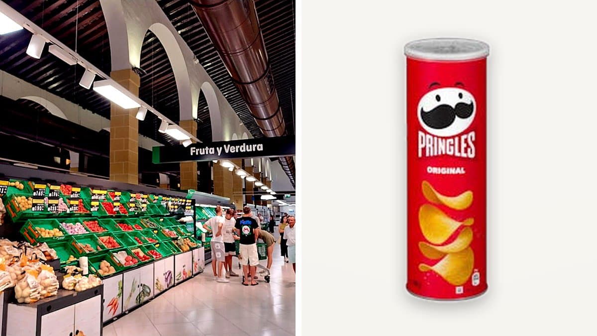 Tubo de Pringles abierto sobre mesa de madera con algunas patatas esparcidas, luz suave de lámpara.