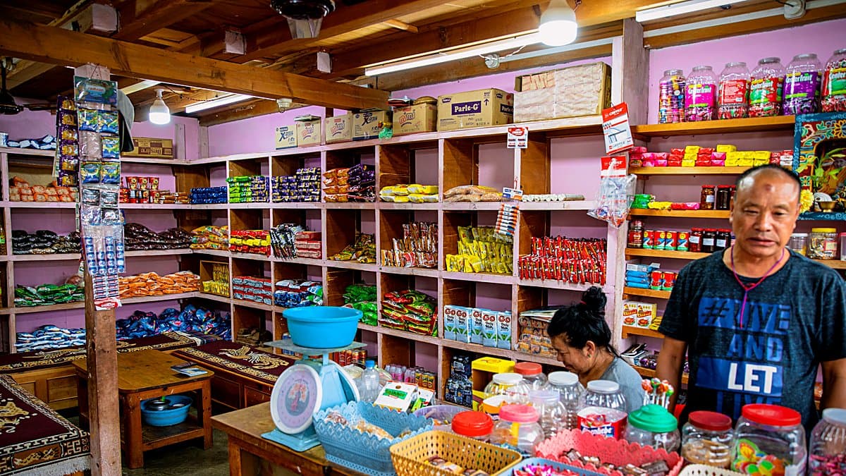Tres carritos de compra idénticos alineados sobre fondo gris con productos de supermercado