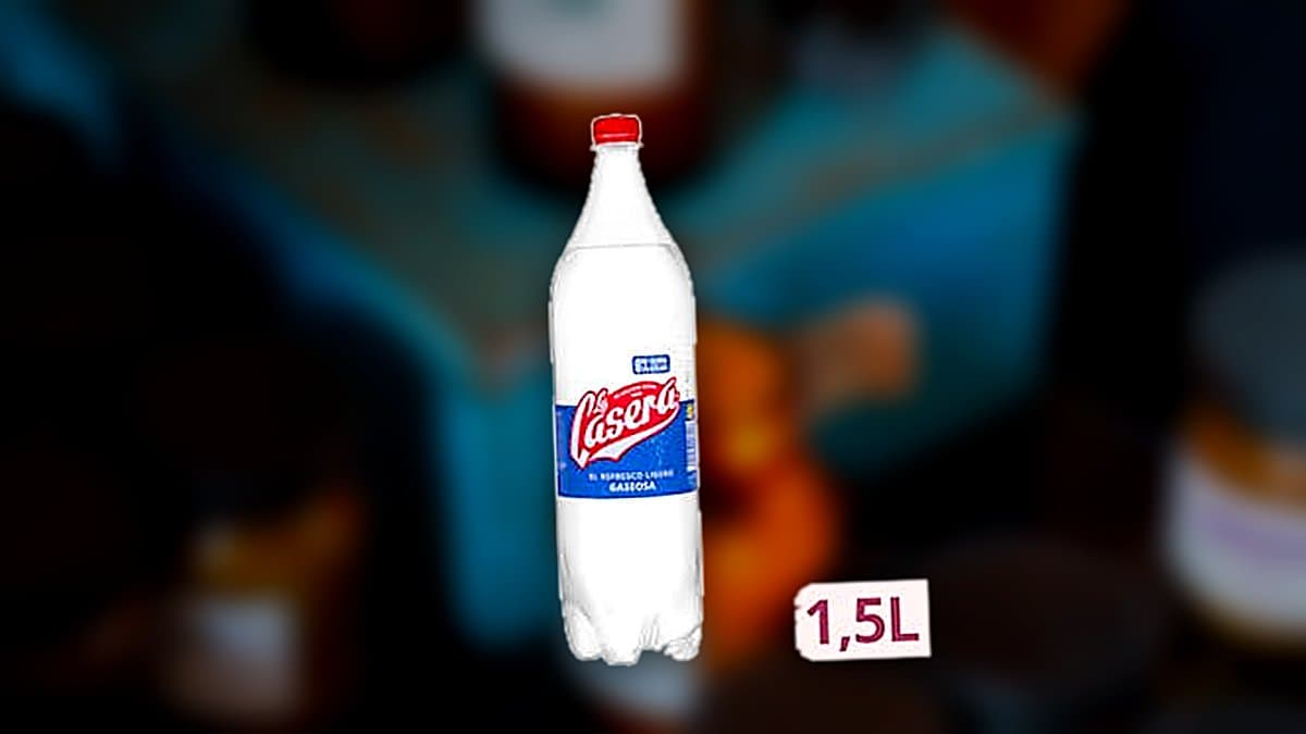 Botella de litro y medio de gaseosa La Casera junto a una copa de vino con hielo en una terraza al atardecer