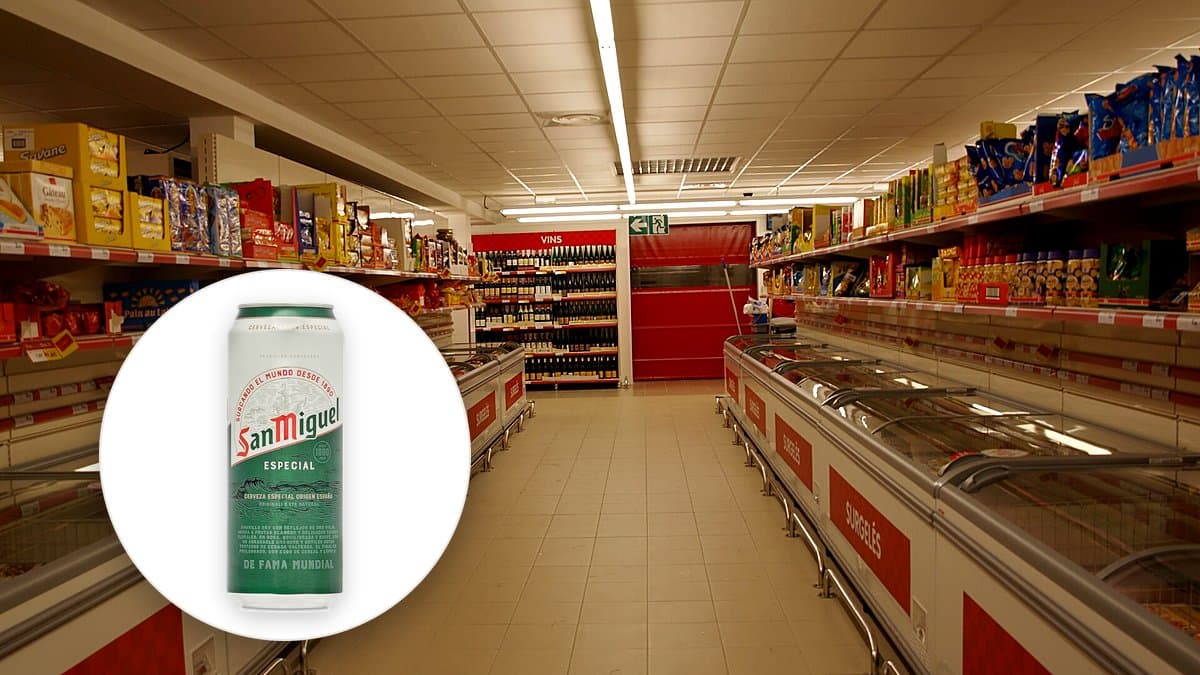 Mesa de café de un salón con cervezas San Miguel de medio litro, aceitunas y patatas, partido de fútbol en la tele