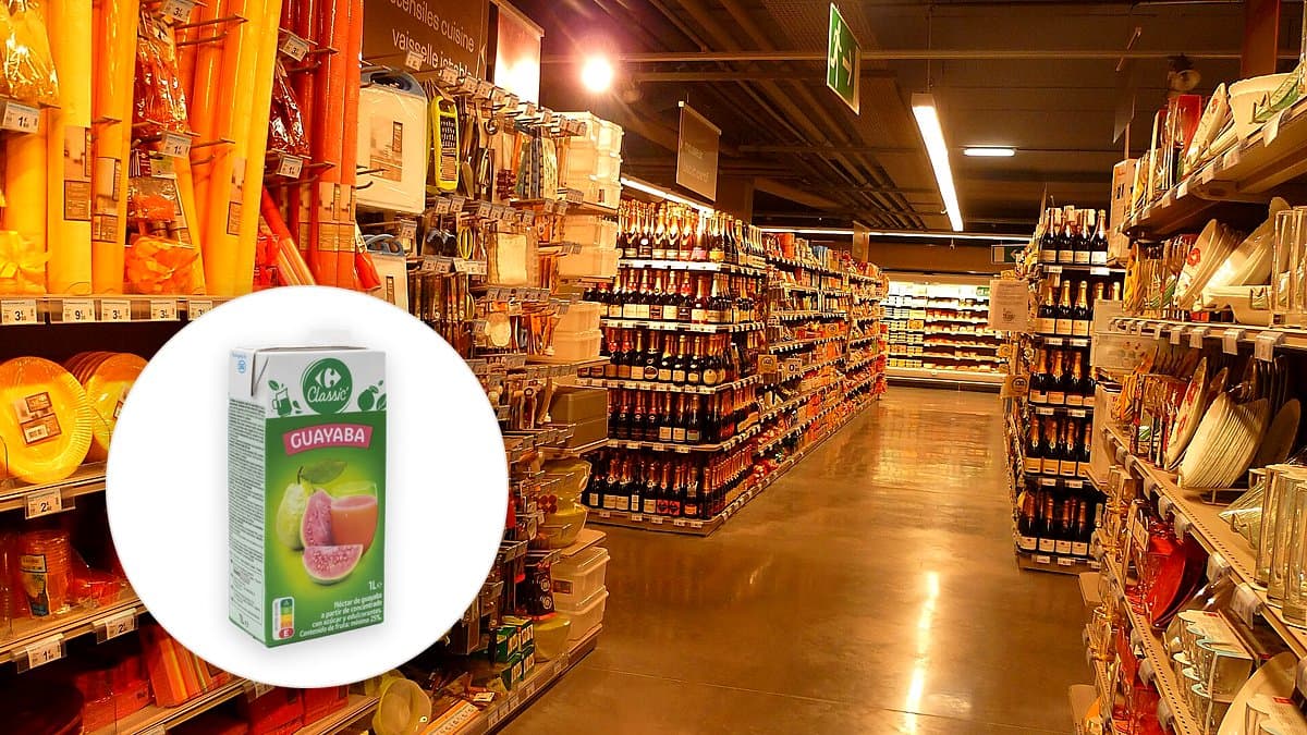 Brik de néctar de guayaba Carrefour con etiqueta visible en estantería de supermercado junto a guayabas cortadas