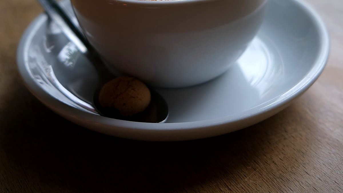 Mesa de desayuno con bolsa de café molido y envases de yogur Danone bajo luz natural matinal
