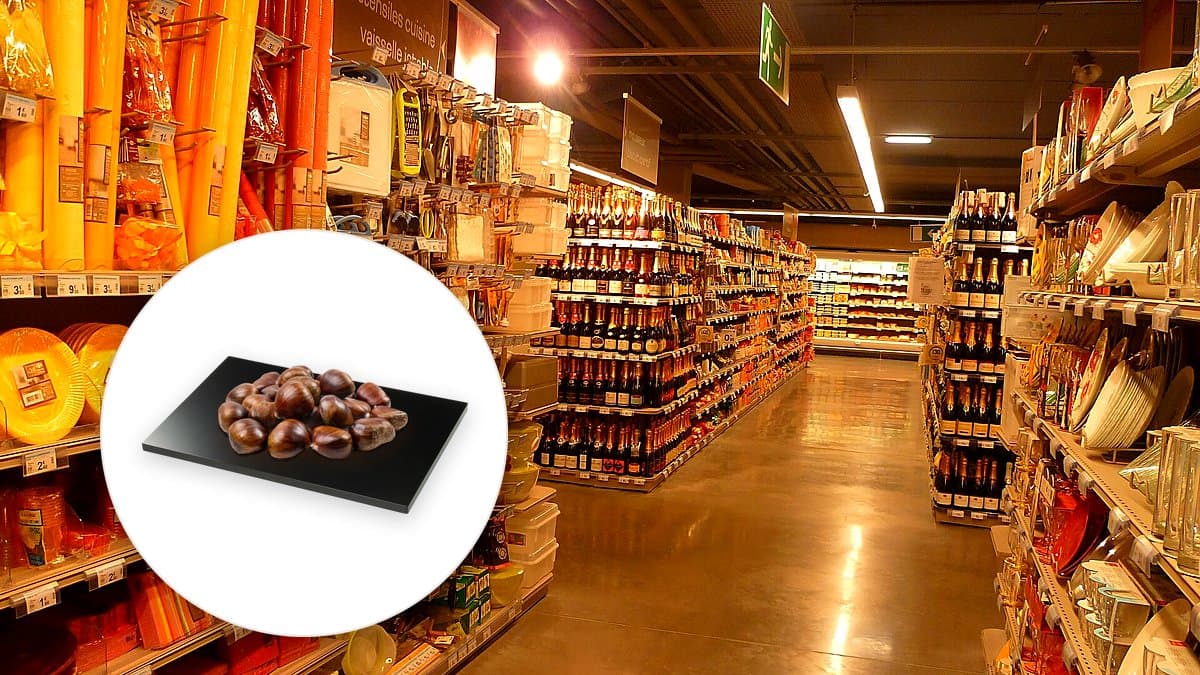 Cesta de mercado con castañas tostadas, calabaza cortada y setas sobre madera rústica, iluminación cálida dorada