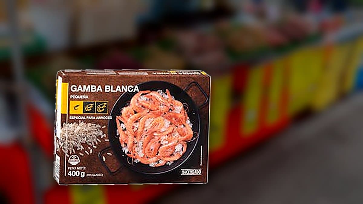 Caja de gambaras arroceras congeladas Hacendado junto a una paella con arroz blanco sobre una mesa de cocina con luz cálida