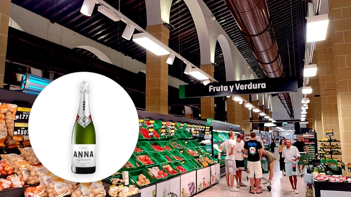 Botella de cava brut Anna de Codorníu en una mesa festiva con copas vacías, luz cálida