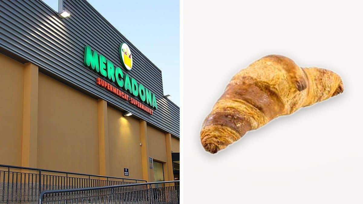 Croissant de mantequilla dorado en plato junto a café en mesa de madera, luz natural otoñal